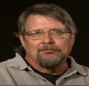 David Wiley's business picture Brown Hair, Glasses, with a grey shirt.