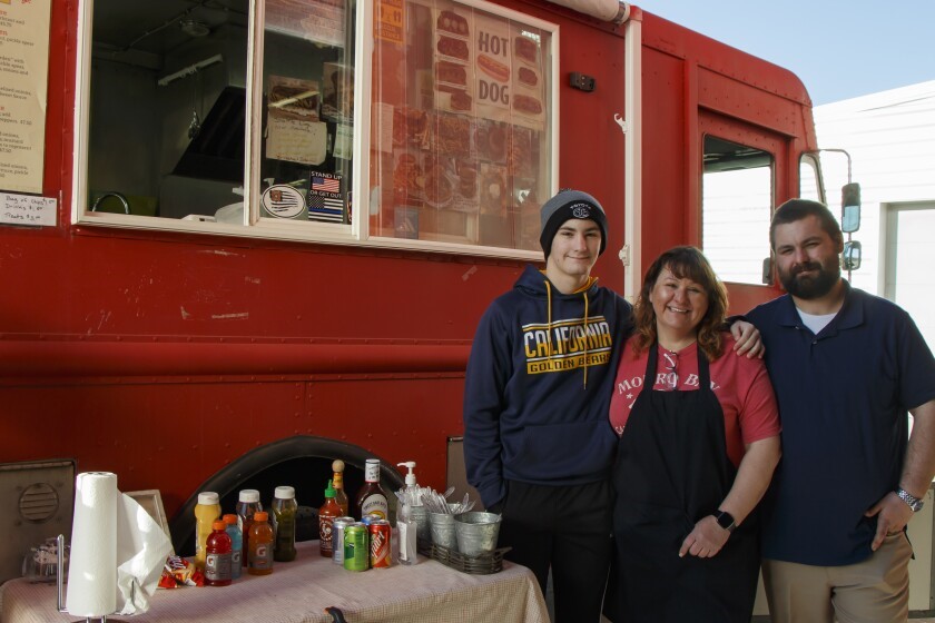 Kristina poses in front of the red food truck she used to own with her two boys Alec and Cameron.